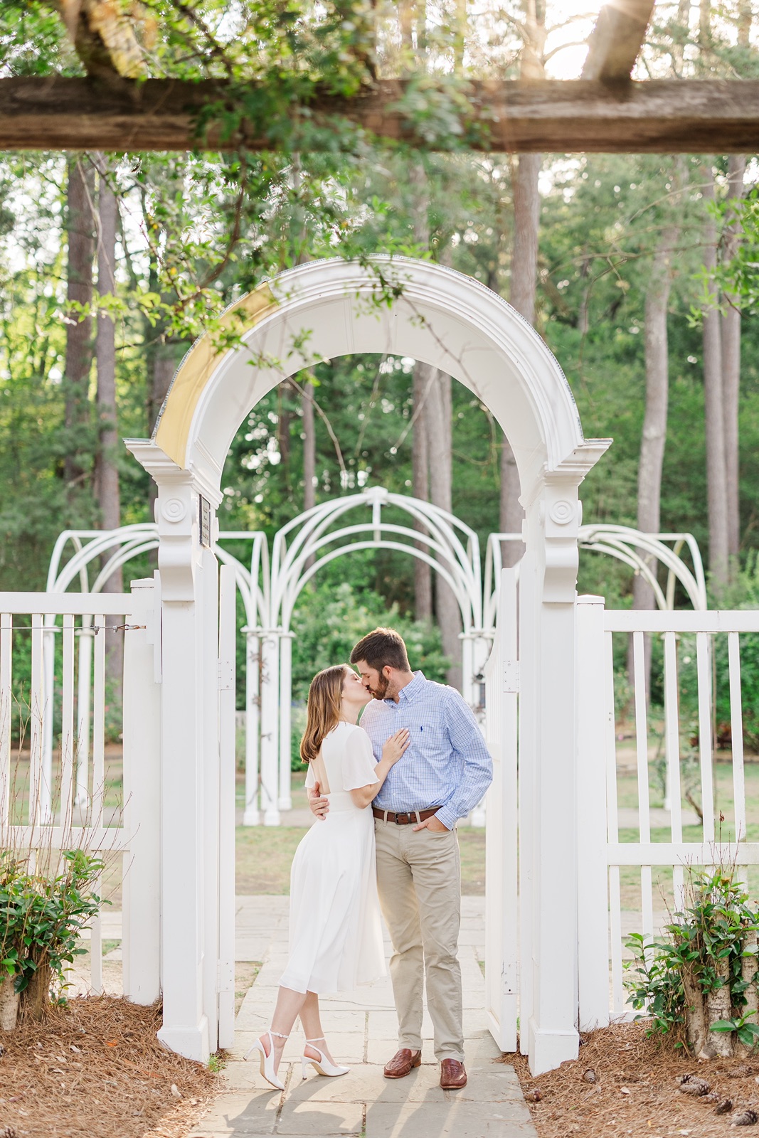 Engagement photo of couple kissing under the archway at the Birmingham Botanical Gardens