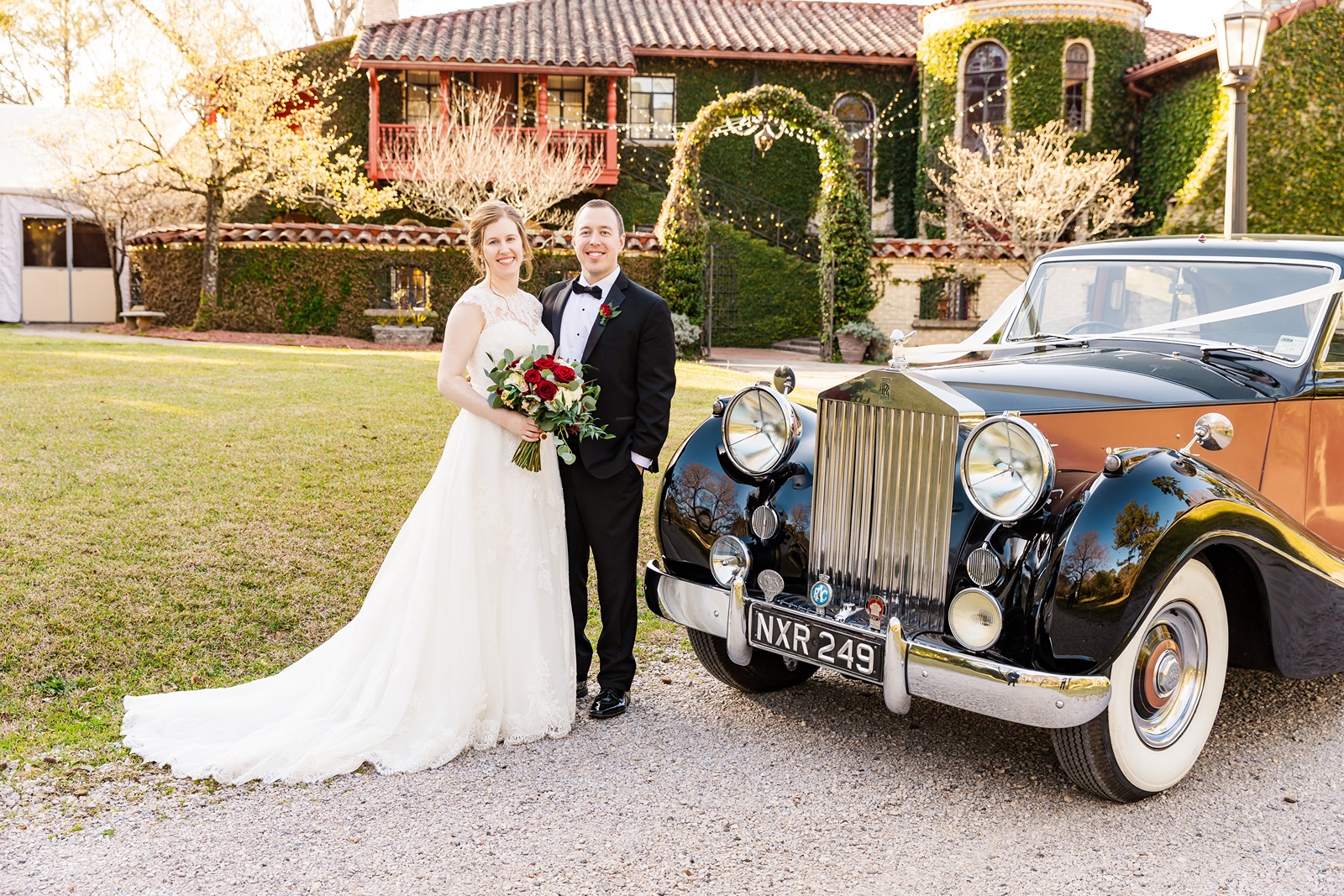 Bride and groom pose next to a Rolls-Royce.